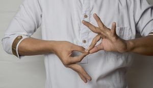 A person with only the middle of the body visible, makes a gesture with both hands.