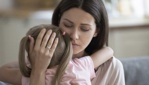 A woman comforts a young girl with a hug
